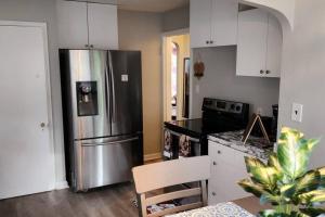 a kitchen with a stainless steel refrigerator and white cabinets at Beautiful 4 bedroom in Euclid in Euclid