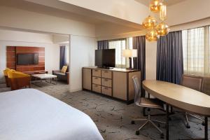 a hotel room with a bed and a desk and a table at Sheraton Gateway Los Angeles Hotel in Los Angeles