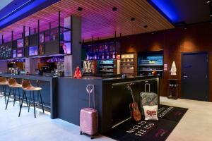 un bar con una maleta y un bar con una guitarra en Moxy Brussels City Center, en Bruselas