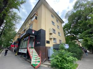 a building with a staircase in front of it at Новые великолепные апартаменты в центре, Желтоксан 159 in Almaty