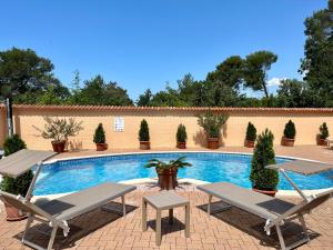 uma piscina com duas espreguiçadeiras e uma mesa em Apartments Villa Julia em Pakoštane