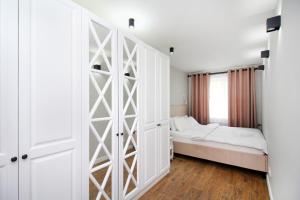 a bedroom with a bed and a large white closet at Новые великолепные апартаменты в центре, Желтоксан 159 in Almaty