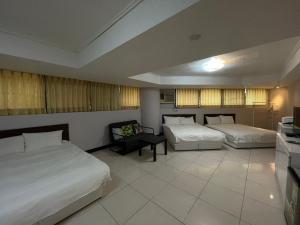 a hotel room with two beds and a tv at Funny Ximen Hotel in Taipei