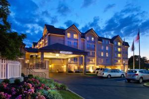 a hotel with cars parked in a parking lot at Sheraton Great Valley Hotel in Frazer