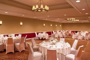 una sala de banquetes con mesas blancas y sillas blancas en Sheraton Great Valley Hotel, en Frazer