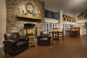 a living room with chairs and a stone fireplace at Sheraton Great Valley Hotel in Frazer