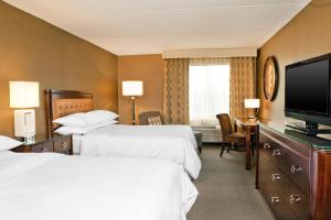 um quarto de hotel com duas camas e uma televisão de ecrã plano em Sheraton Great Valley Hotel em Frazer