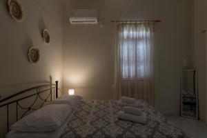 Un dormitorio con una cama con sábanas blancas y una ventana. en Katrin's House, en Lixouri