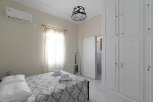 Un dormitorio blanco con una cama y una ventana. en Katrin's House, en Lixouri