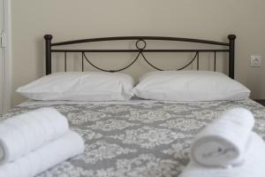 1 cama con sábanas blancas, almohadas y toallas en Katrin's House, en Lixouri 20 fotos más