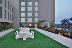 a room with white tables and chairs on the grass at Courtyard by Marriott Siliguri in Siliguri
