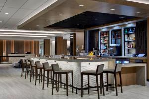 a bar with a row of stools in a restaurant at AC Hotel by Marriott Orlando Lake Buena Vista in Orlando
