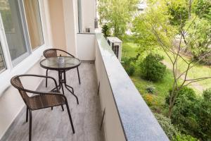 a small table and chairs on a balcony with a view at Alagen Apartments Burgas in Burgas City