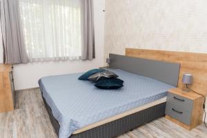 a bed with two pillows on it in a bedroom at Alagen Apartments Burgas in Burgas City