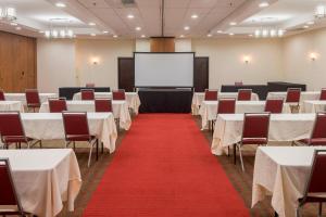 una sala conferenze con tavoli, sedie e schermo di Four Points by Sheraton Asheville Downtown ad Asheville