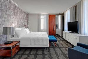 Habitación de hotel con cama y TV en Le Meridien Indianapolis en Indianápolis