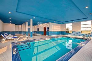 舍伍德公園的住宿－Four Points by Sheraton Sherwood Park，一座拥有蓝色天花板的大型游泳池