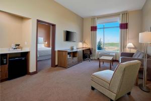 a hotel room with a bed and a desk and a chair at Four Points by Sheraton Sherwood Park in Sherwood Park