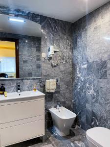 a bathroom with a sink and a toilet and a mirror at Goya Apartamento Centro in Madrid