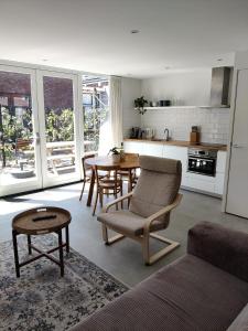 ein Wohnzimmer mit einem Tisch und Stühlen sowie eine Küche in der Unterkunft Zilt aan Zee in Egmond aan Zee