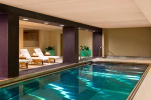 a swimming pool in a hotel with chairs and a room at The Westin Minneapolis in Minneapolis
