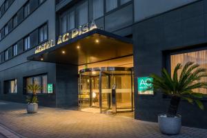 a building with a sign on the front of it at AC Hotel by Marriott Pisa in Pisa