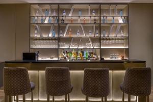 um bar com quatro cadeiras em frente em AC Hotel by Marriott Pisa em Pisa