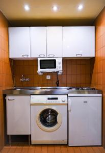 a kitchen with a washing machine and a microwave at Goya Apartamento Centro in Madrid