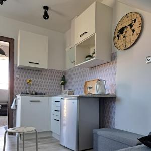 a kitchen with white cabinets and a white refrigerator at Mały Apartamencik Teo in Rewal