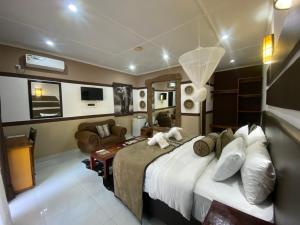 sypialnia z dużym łóżkiem i salonem w obiekcie Ngoma Zanga Lodge w mieście Livingstone