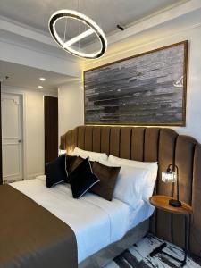 um quarto com uma cama grande e almofadas pretas e brancas em MAKATI Prime Luxury em Manila