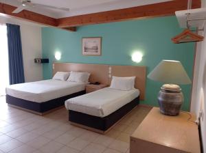 una habitación de hotel con 2 camas y una lámpara en The San Anton Hotel en St Paul's Bay