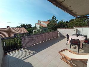 a patio with a table and chairs on a balcony at Sonja Apartment in Premantura