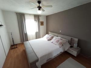 a bedroom with a white bed and a ceiling fan at Sonja Apartment in Premantura