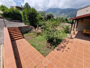 a patio with a brick walkway next to a house at Casa vacanze Dafne in Mandra Capreria