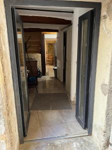una puerta abierta a un pasillo con suelo de baldosa en APPARTEMENT CAROMB proche Mont VENTOUX avec clim, en Caromb