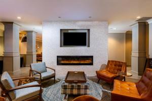 sala de estar con chimenea y TV en Four Points by Sheraton St. Louis - Fairview Heights, en Fairview Heights