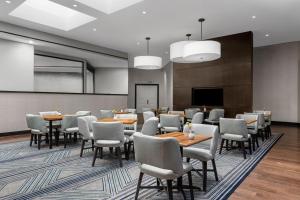 una sala conferenze con tavoli, sedie e schermo di Pleasanton Marriott a Pleasanton