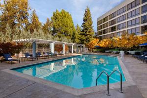 a pool at a hotel with chairs and a building at Pleasanton Marriott in Pleasanton