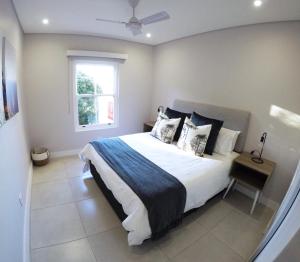 a bedroom with a large bed and a window at Stylish Sea View Apartment in Santorini Estate. in Ballito