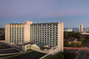 a large white hotel building with a city in the background at Sheraton Myrtle Beach in Myrtle Beach