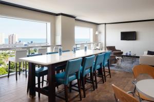 a dining room with a large table and blue chairs at Sheraton Myrtle Beach in Myrtle Beach