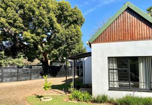 a house with a red roof and a tree at The White House in Hartbeespoort