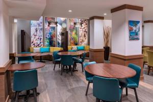 a waiting room with tables and chairs and paintings at Courtyard by Marriott Nassau Downtown/Junkanoo Beach in Nassau
