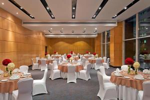 un salón de banquetes con mesas blancas y sillas blancas en Fairfield by Marriott Lucknow, en Lucknow