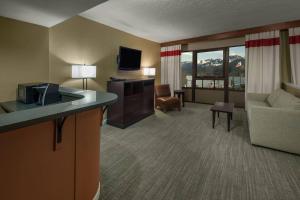 a hotel room with a couch and a television and a living room at Four Points by Sheraton Juneau in Juneau