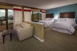 um quarto de hotel com duas camas e uma cadeira em Four Points by Sheraton Juneau em Juneau