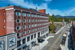 ein großes rotes Backsteingebäude in einer Stadtstraße in der Unterkunft Grand Adirondack Hotel, Lake Placid, a Tribute Portfolio Hotel in Lake Placid