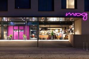 un magasin de macy devant la nuit avec un signe de néon violet dans l'établissement Moxy Rust, à Rust