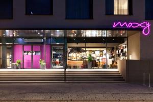 a macy store front at night with a purple neon sign at Moxy Rust in Rust